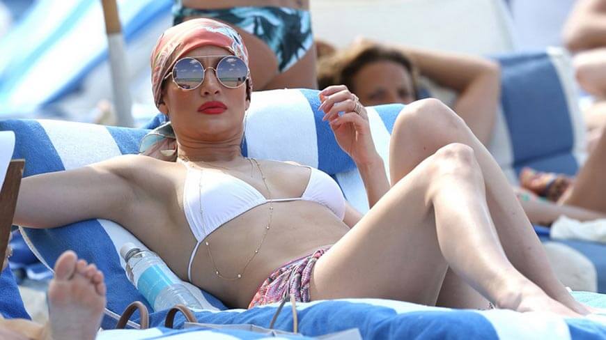 jennifer-lopez-sexy-bikini-photos-lying-on-beach-on-bed-in-white-swimsuit-sexy-leg-picture-clicked